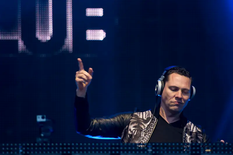 DJ performing under blue stage lighting at a live show